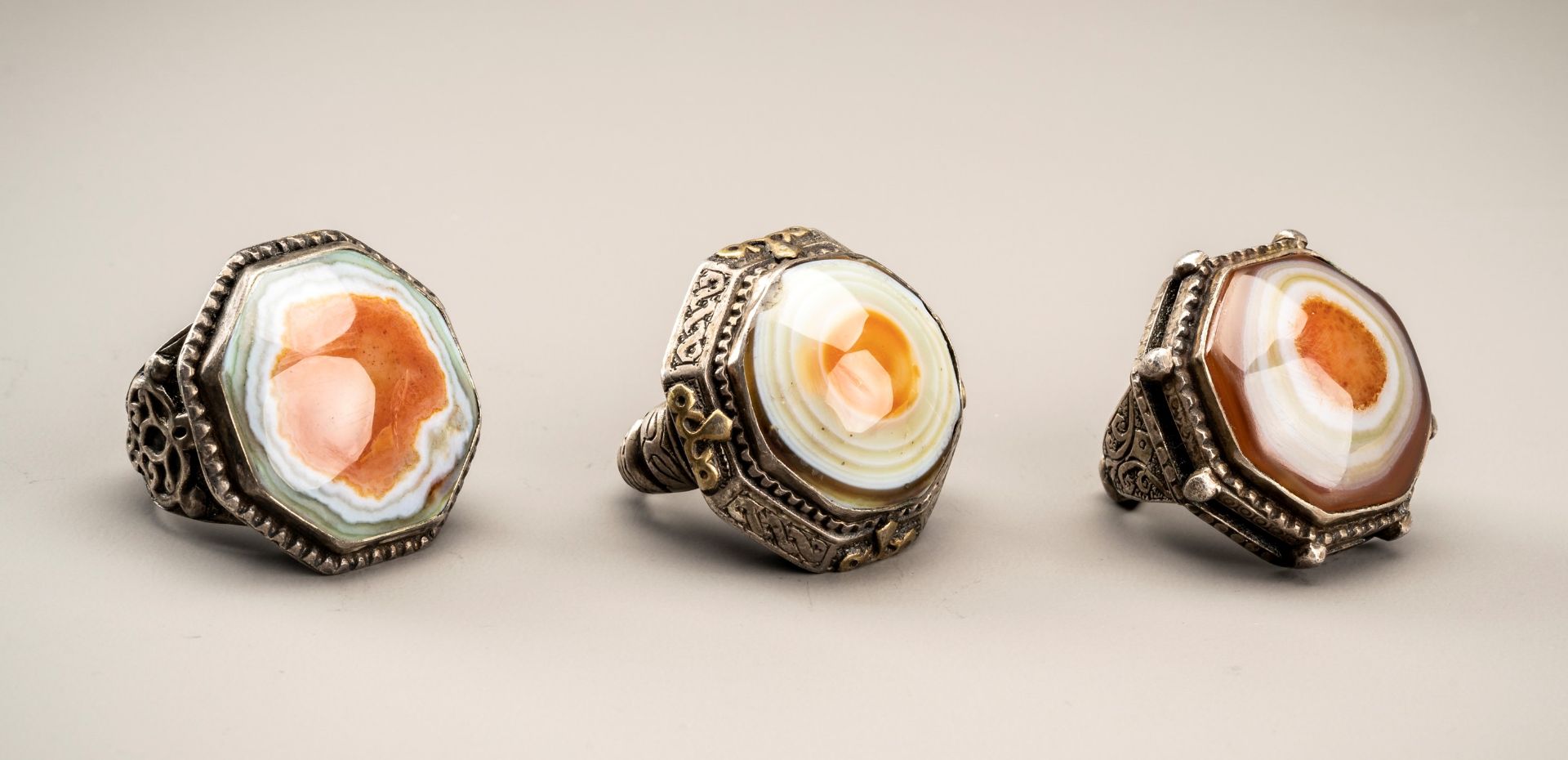 A GROUP OF THREE HIMALAYAN BUDDHA EYE AGATE INSET SILVER RINGS