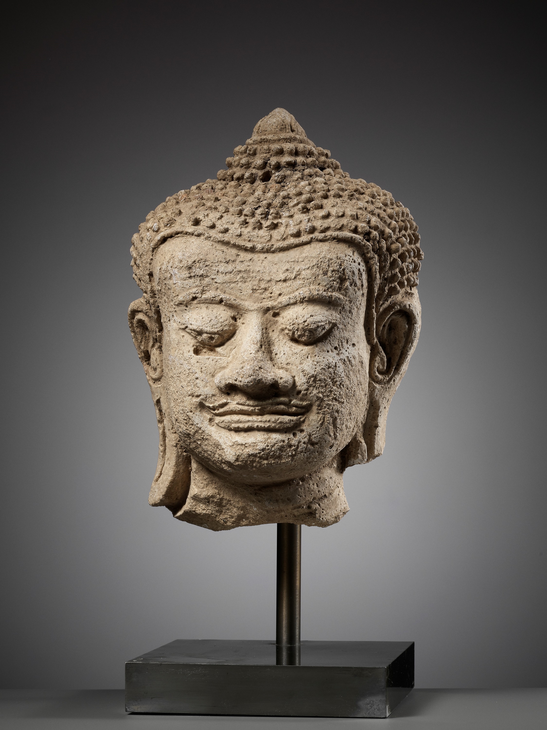 A HARIPUNJAYA STUCCO HEAD OF BUDDHA, THAILAND, 11TH-13TH CENTURY