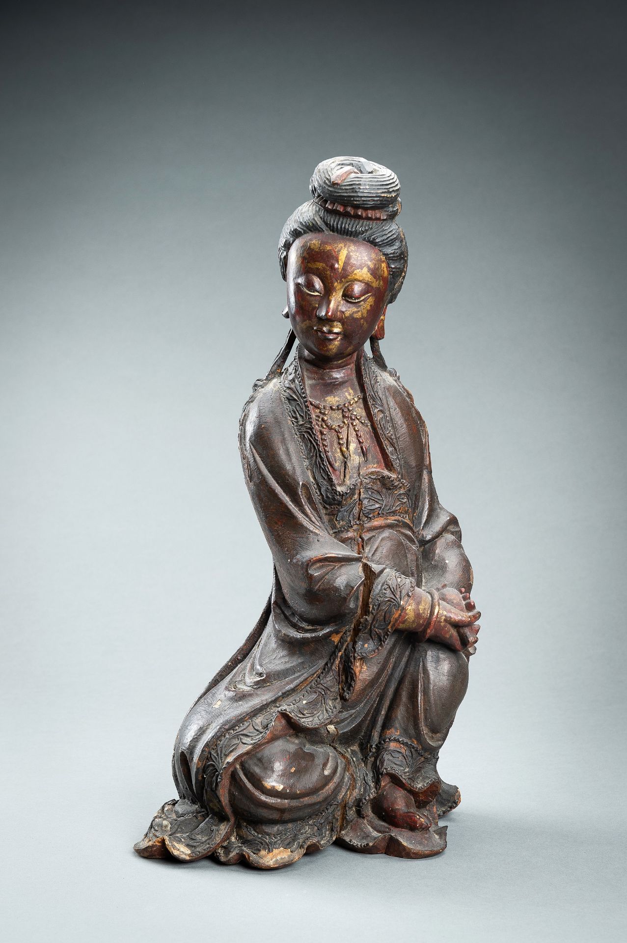 A RED AND GILT-LACQUERED WOOD FIGURE OF GUANYIN, QING DYNASTY