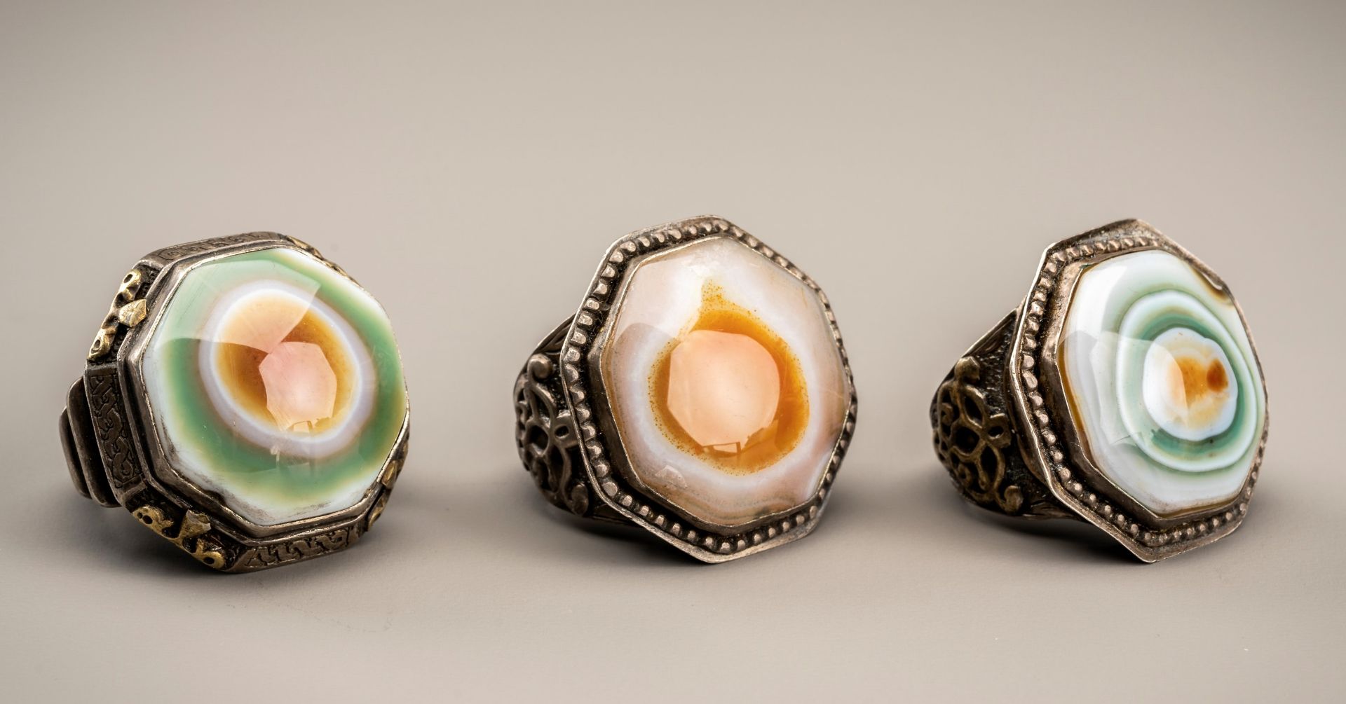 A GROUP OF THREE HIMALAYAN BUDDHA EYE AGATE INSET SILVER RINGS