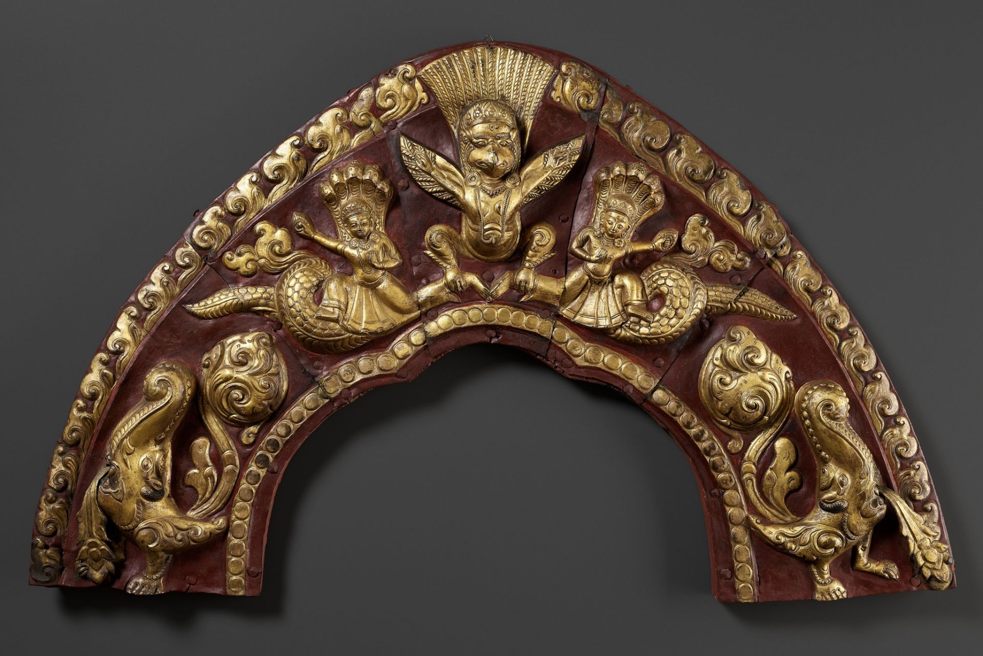 A LARGE GILT AND LACQUERED COPPER REPOUSSE TORANA, NEPAL, 17TH-18TH CENTURY