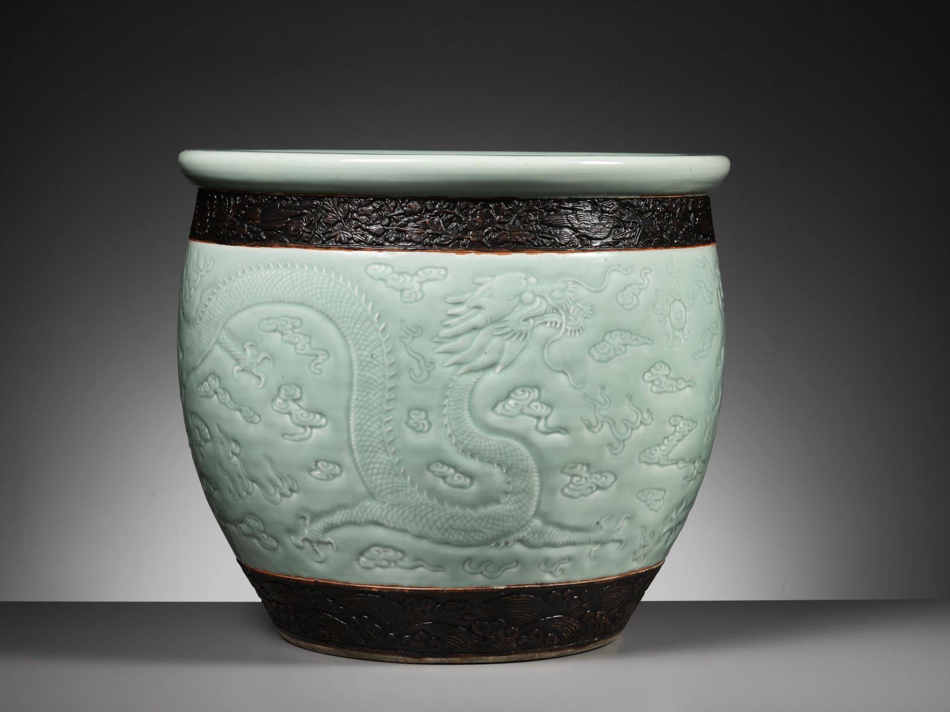 A LARGE MOLDED AND CARVED CELADON-GLAZED 'DRAGON' FISHBOWL, QING DYNASTY - Image 12 of 16