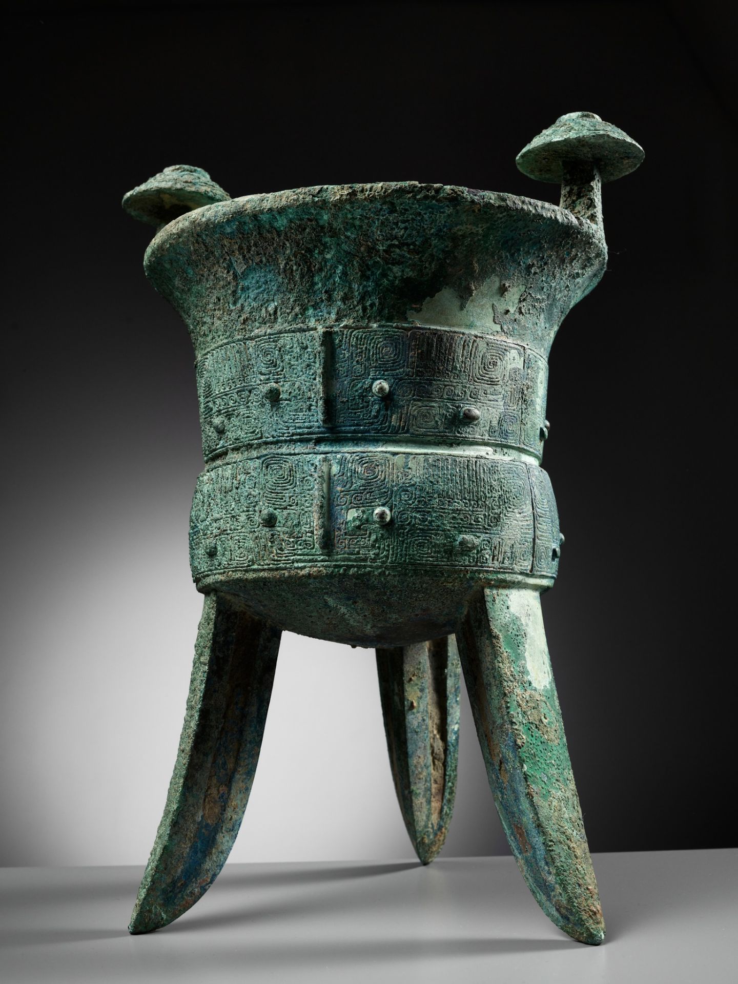 AN EXCEPTIONALLY LARGE AND MASSIVE BRONZE RITUAL TRIPOD WINE VESSEL, JIA, WITH A CLAN MARK, SHANG