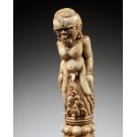 A CARVED BONE KRIS HILT IN THE FORM OF A MALE DEMON, INDONESIA, 18TH-19TH CENTURY