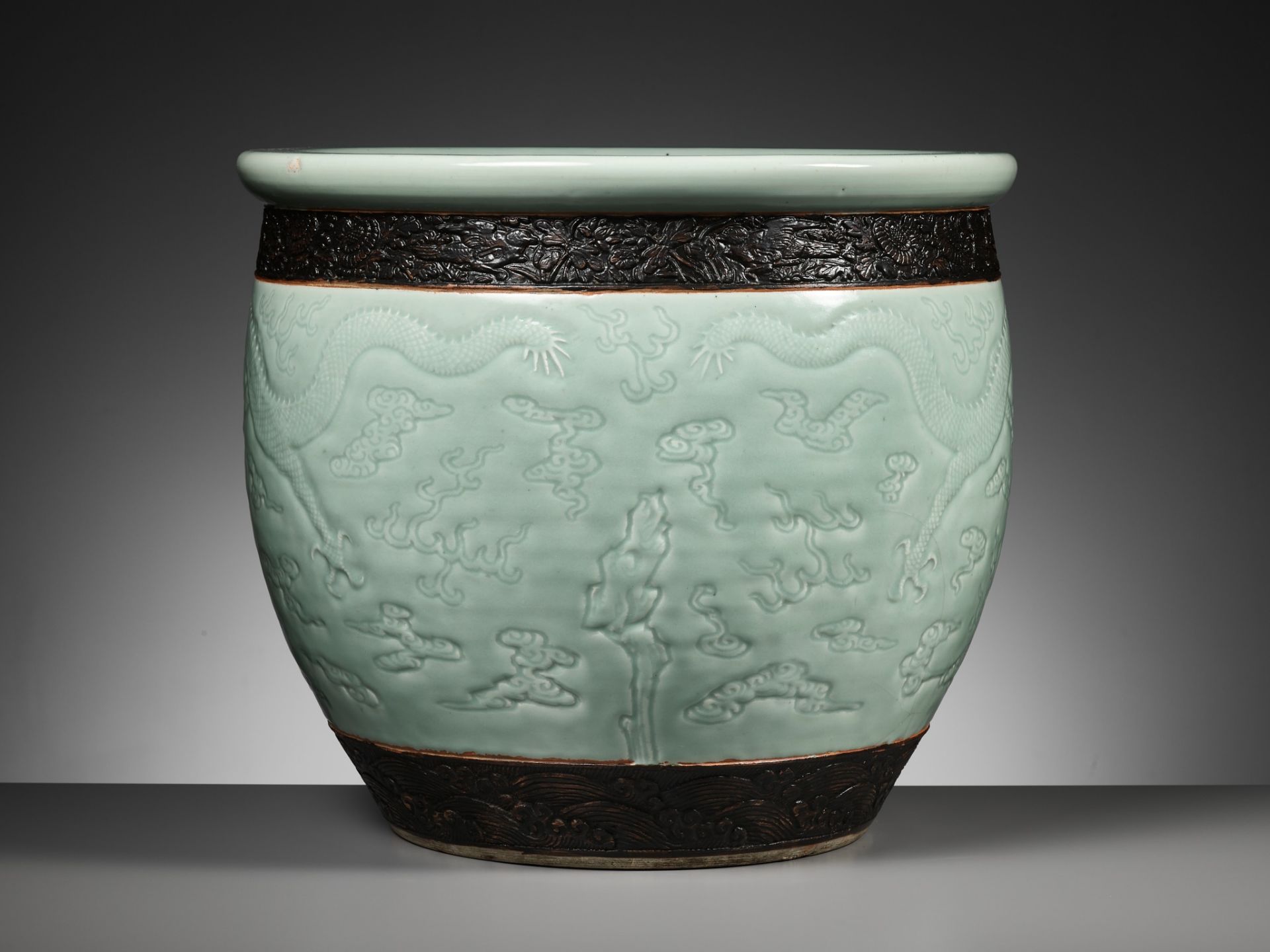 A LARGE MOLDED AND CARVED CELADON-GLAZED 'DRAGON' FISHBOWL, QING DYNASTY - Image 10 of 16
