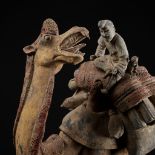 A LARGE PAINTED POTTERY FIGURE OF A BACTRIAN CAMEL WITH RIDER, MONKEY AND SLAIN GOATS, TANG
