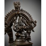 A BRONZE STATUE OF VISHNU HOLDING THE INFANT BRAHMA ON A SHRINE, NAYAK PERIOD