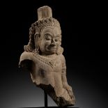 A SANDSTONE BUST OF A DEMON, ASURA, ANGKOR PERIOD