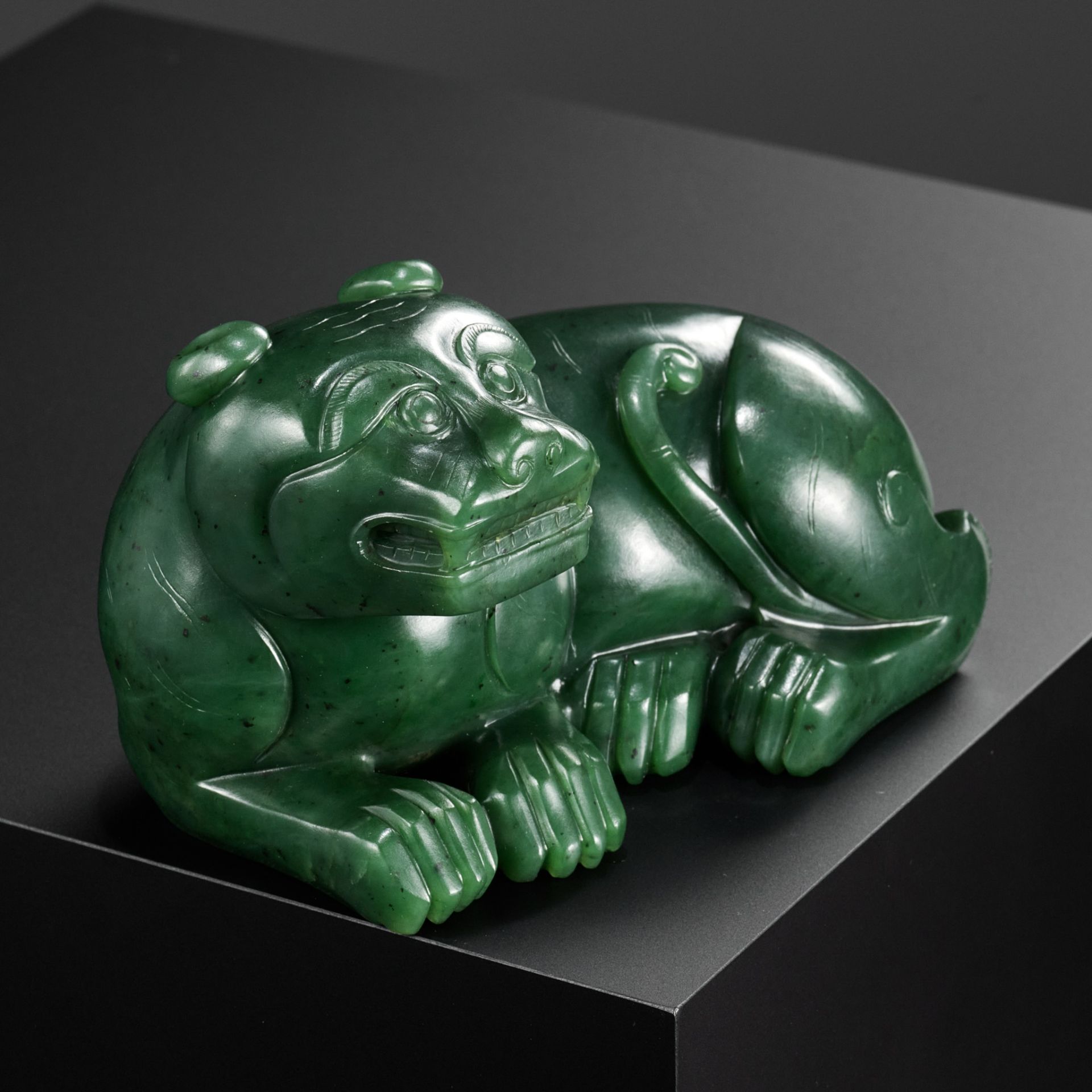 A RARE SPINACH-GREEN JADE FIGURE OF A TIGER, SECOND HALF OF THE QIANLONG PERIOD