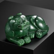 A RARE SPINACH-GREEN JADE FIGURE OF A TIGER, SECOND HALF OF THE QIANLONG PERIOD
