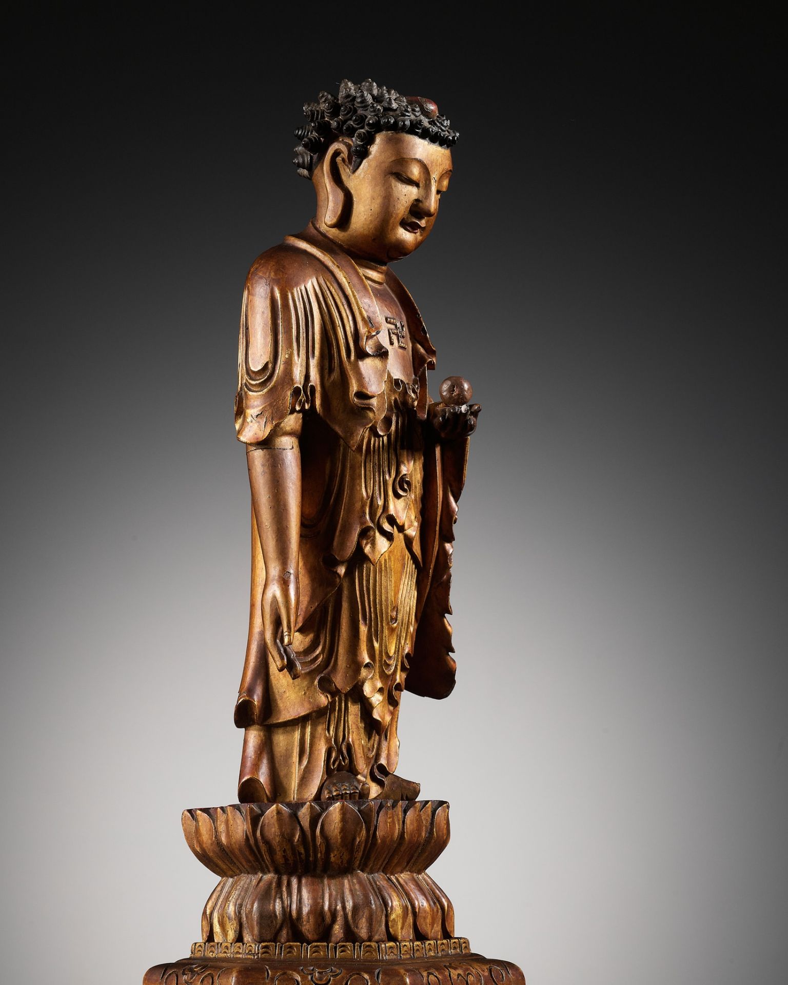 A LACQUER-GILT WOOD FIGURE OF THE STANDING BUDDHA, CHINA, 17TH - 18TH CENTURY
