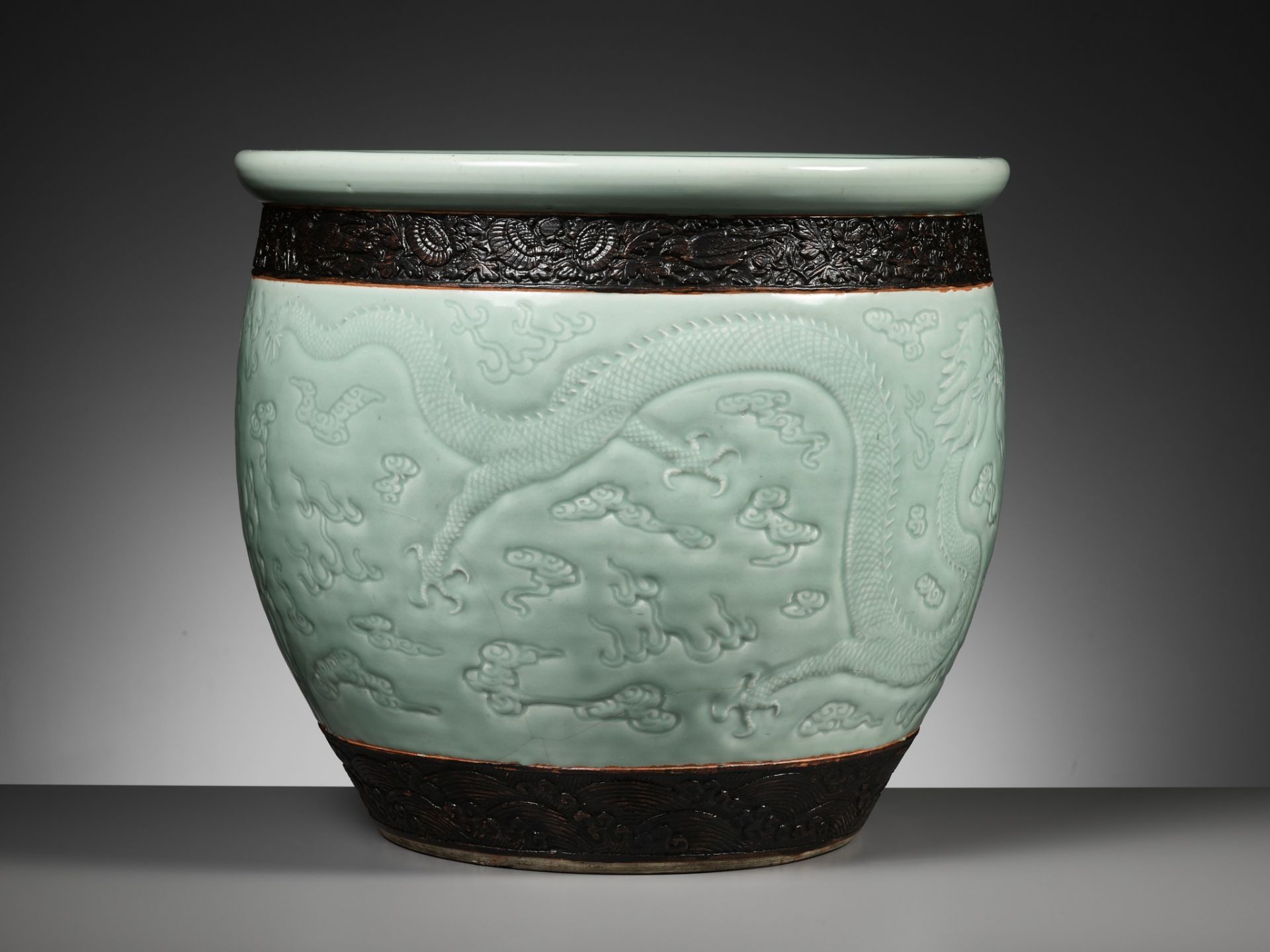 A LARGE MOLDED AND CARVED CELADON-GLAZED 'DRAGON' FISHBOWL, QING DYNASTY - Image 11 of 16