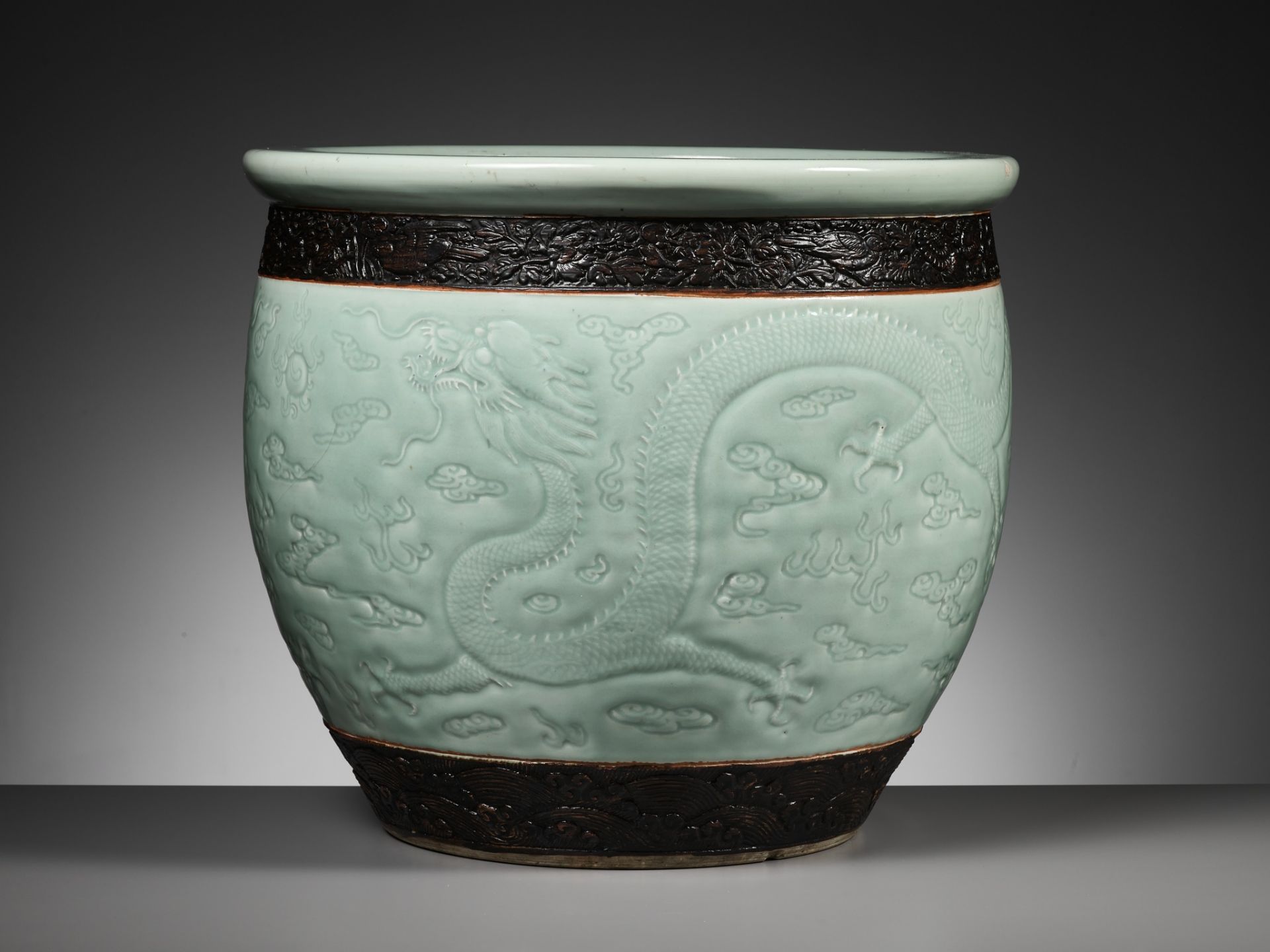 A LARGE MOLDED AND CARVED CELADON-GLAZED 'DRAGON' FISHBOWL, QING DYNASTY - Image 8 of 16