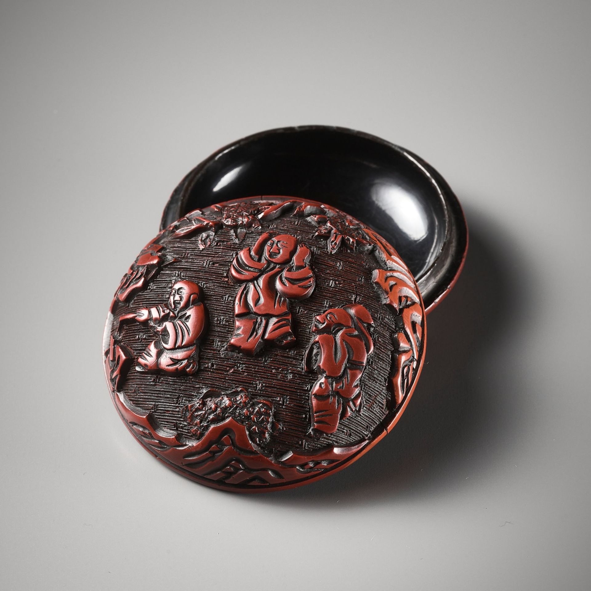 A CINNABAR LACQUER 'PLAYING BOYS' SEAL PASTE BOX AND COVER, MING DYNASTY