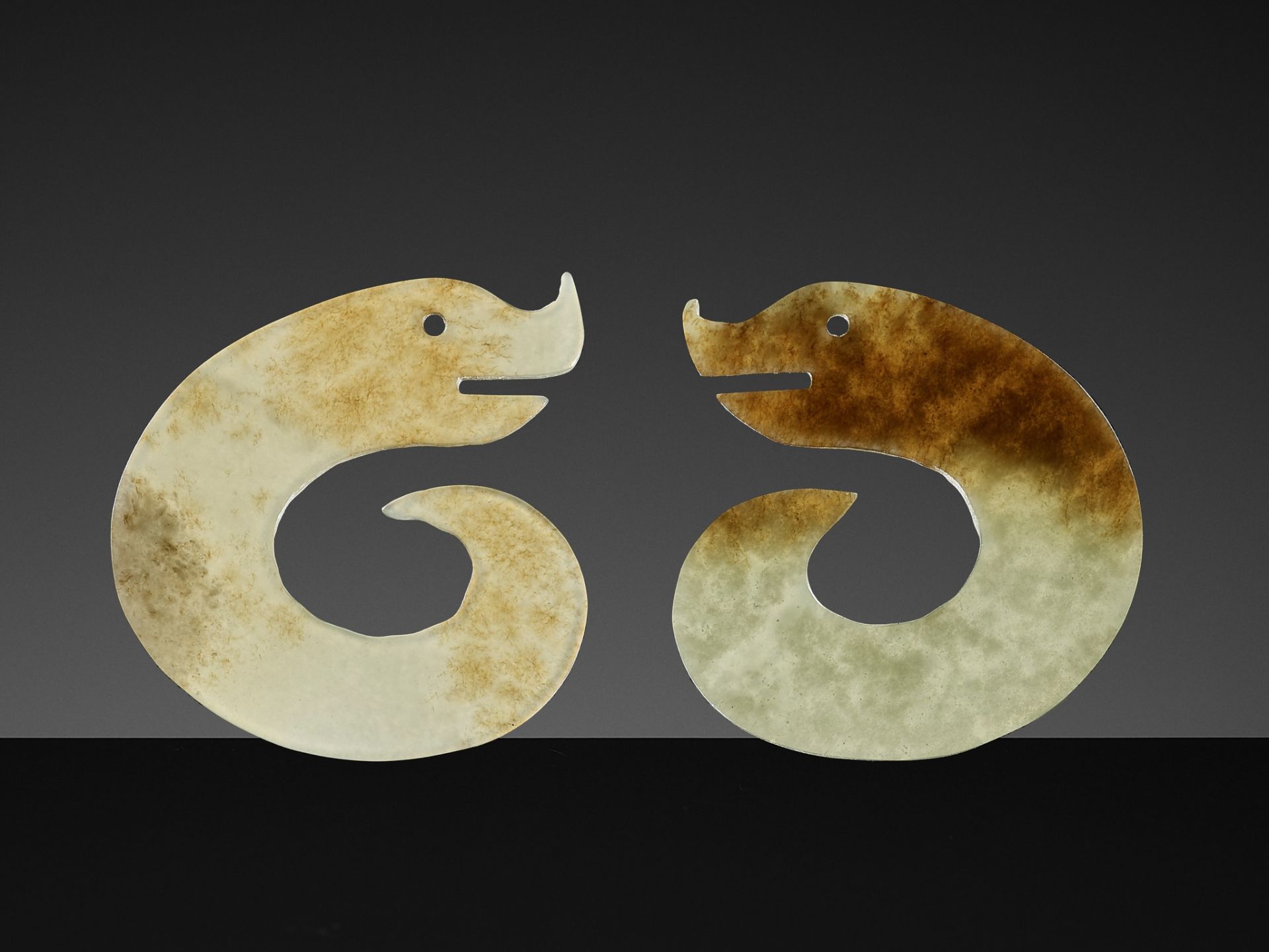 A PAIR OF C-SHAPED 'DRAGON' PENDANTS, ERLITOU PERIOD TO SHANG DYNASTY