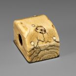 A RARE IVORY NETSUKE OF AN ONI HIDING IN A BOX DURING SETSUBUN