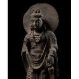 A LARGE SCHIST FIGURE OF MAITREYA WITH ATLAS, ANCIENT REGION OF GANDHARA