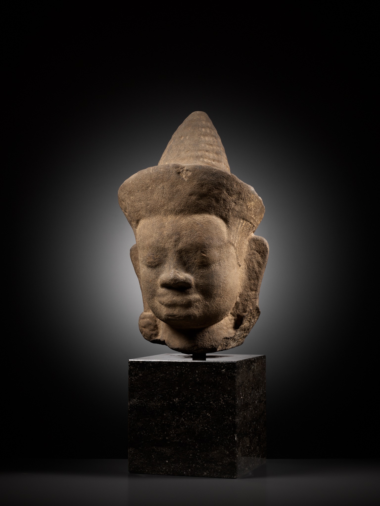 A MONUMENTAL SANDSTONE HEAD OF A MALE DEITY, ANGKOR WAT STYLE - Image 6 of 9