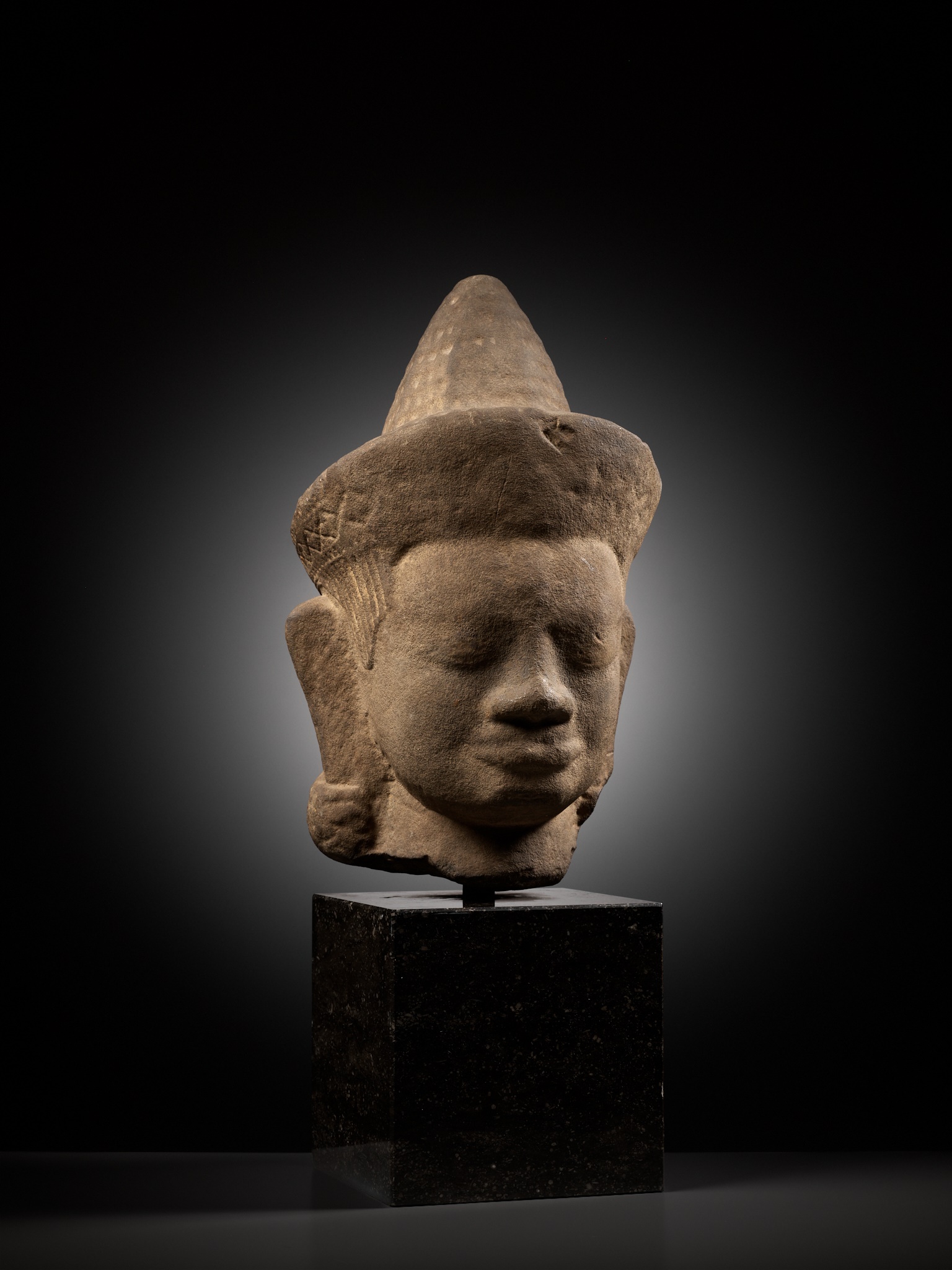 A MONUMENTAL SANDSTONE HEAD OF A MALE DEITY, ANGKOR WAT STYLE - Image 2 of 9