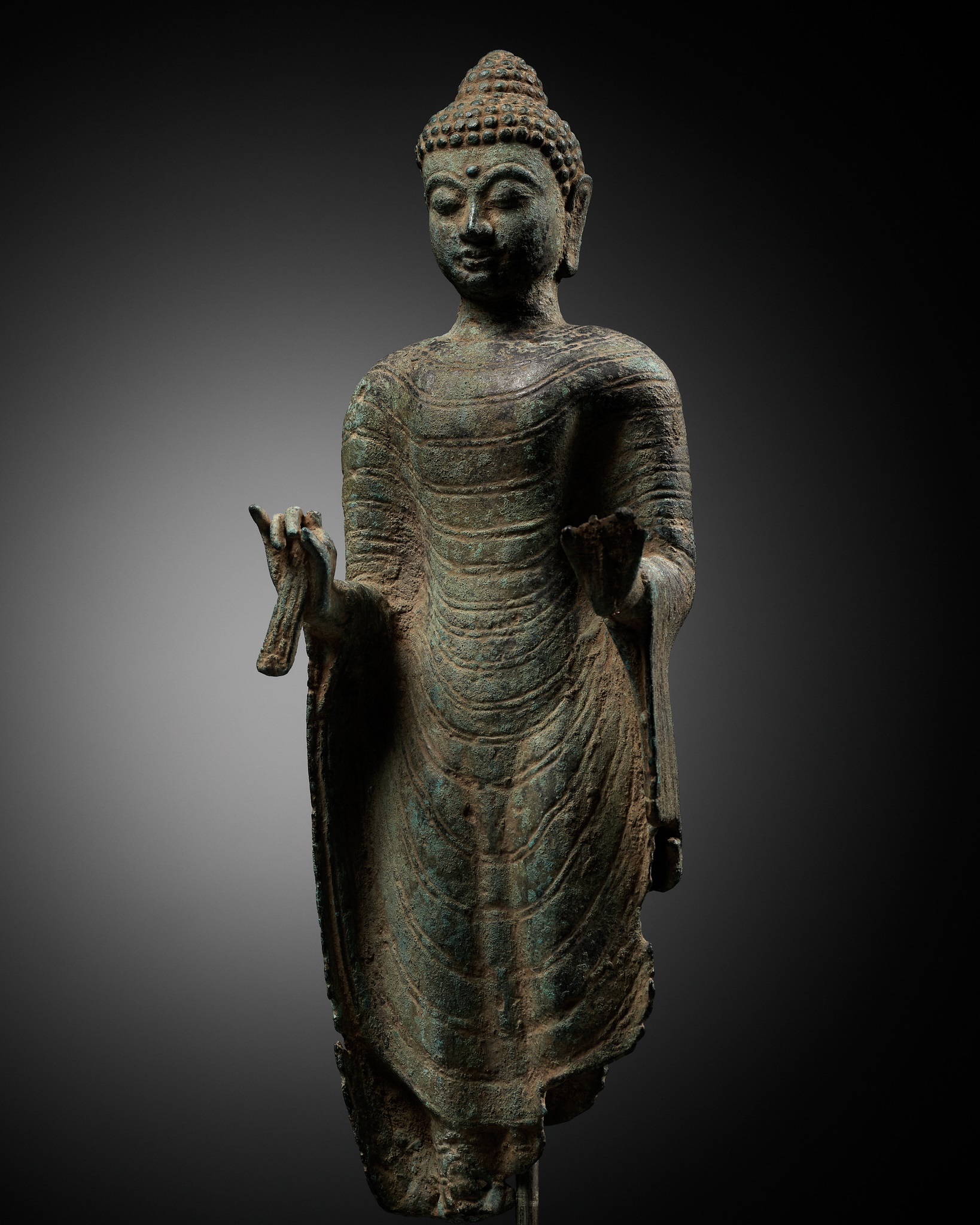 A FRAGMENTARY BRONZE BUST OF BUDDHA, INDONESIA, 16TH-17TH CENTURY