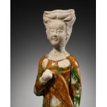 A SANCAI GLAZED POTTERY FIGURE OF A FEMALE MUSICIAN PLAYING THE PIPA, TANG DYNASTY