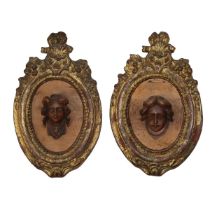 Pair of wall medallions, oval frame in gilded wood and wooden sculptures with embossed faces, 18th