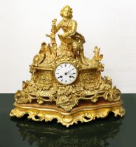 Golden metal clock in display case, nineteenth century