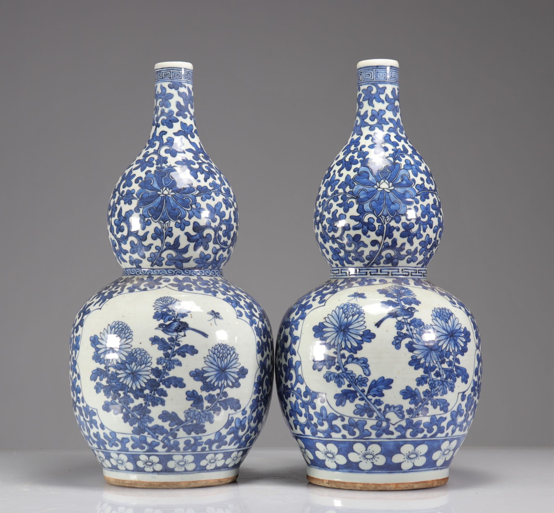 Pair of double-gourd vases in blue-white enamelled porcelain decorated with floriform medallions of