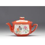 Famille rose porcelain teapot decorated with flowers on a coral background