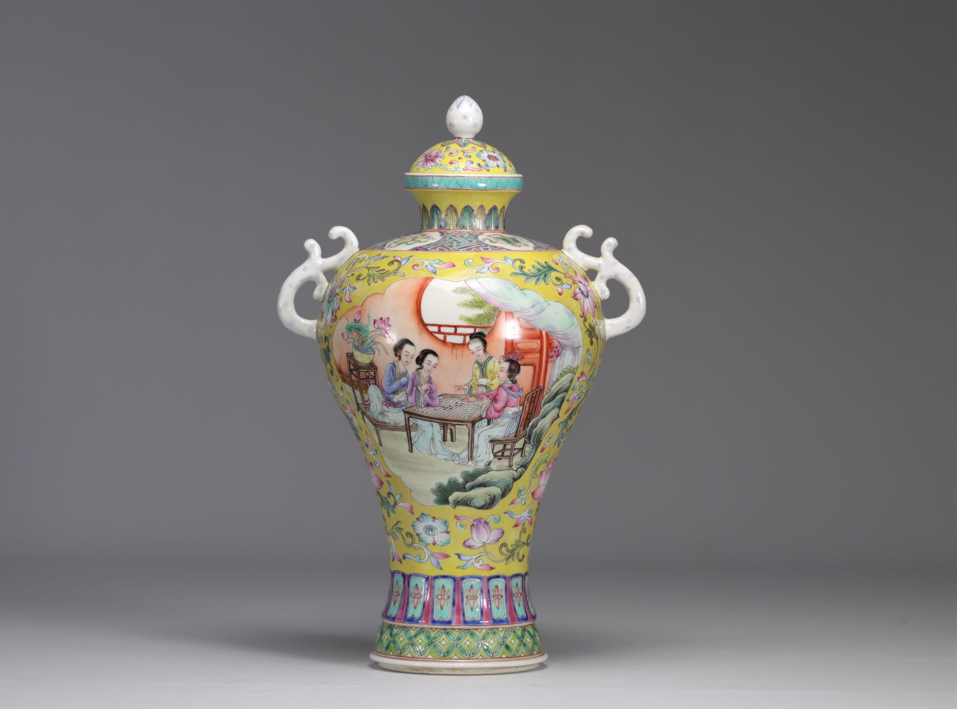 Covered porcelain vase decorated with characters from the Famille Rose on a yellow background