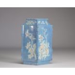 A Chinese porcelain vase decorated with flowers in relief on a light blue background from Qing perio