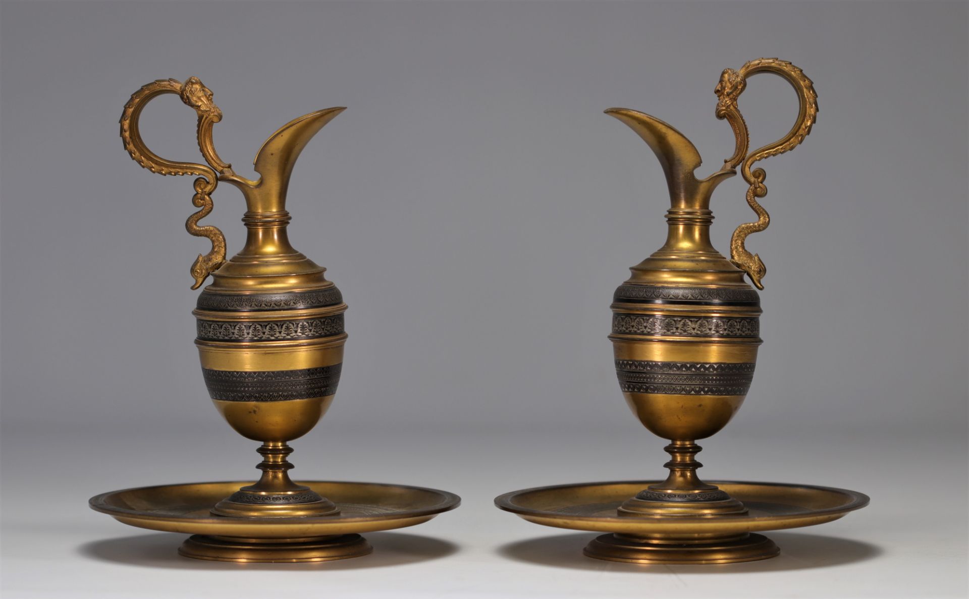 Pair of antique bronze pourers with silver inlay