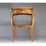 Gilded table decorated with flowers resting on a marble shelf