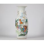 Famille rose porcelain vase decorated with figures and a landscape on a white background