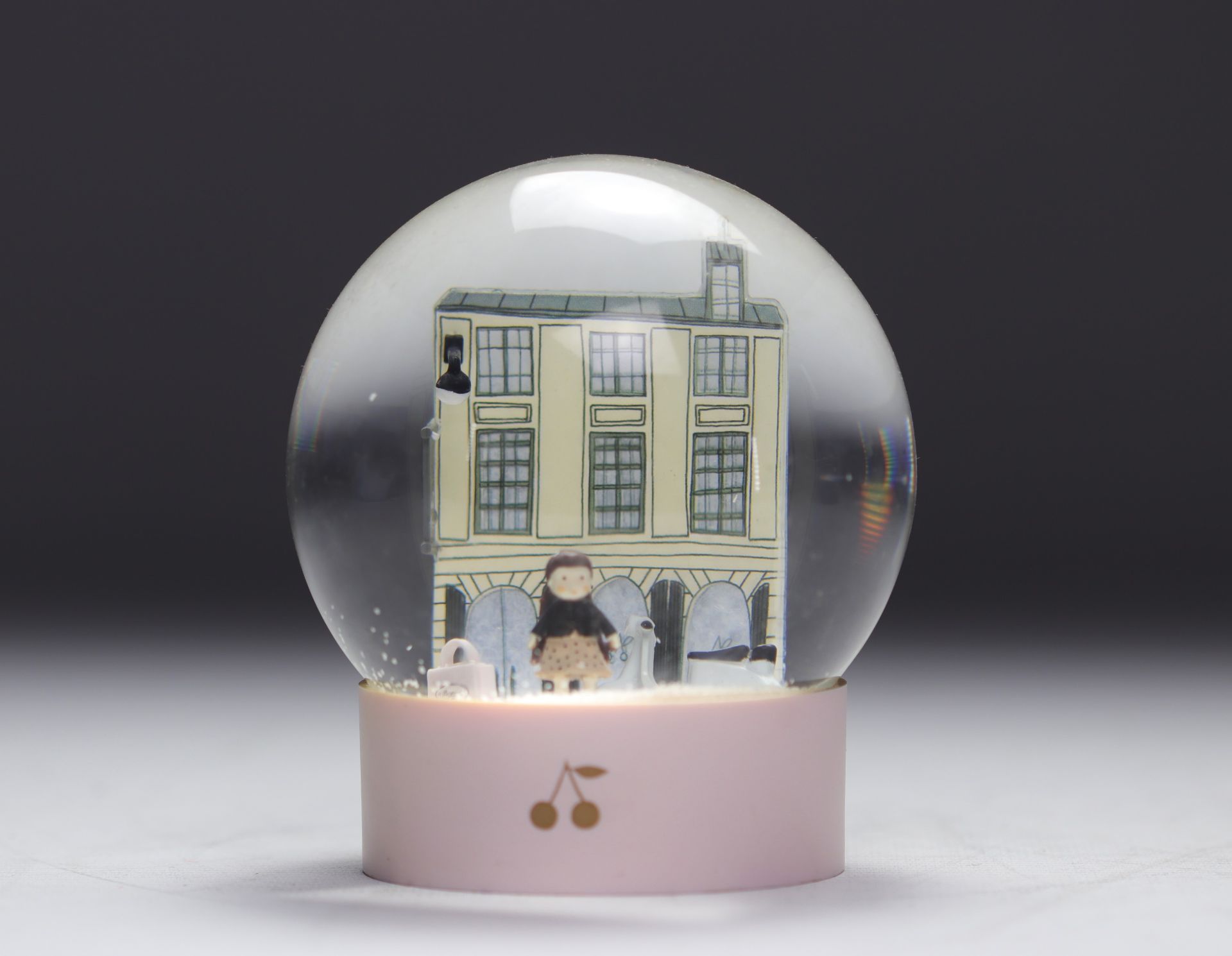 Bonpoint. Snow globe representing the famous Parisian boutique on rue de Tournon with the Cerise dol