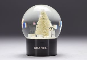 Chanel. Snow globe adorned with the No. 5 perfume bottle, bags, fir tree and topped with the CC log