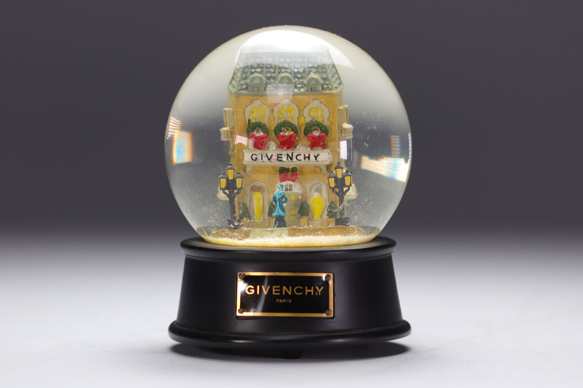 Givenchy. Musical snow globe decorated with the Parisian boutique animated by characters and a Rolls