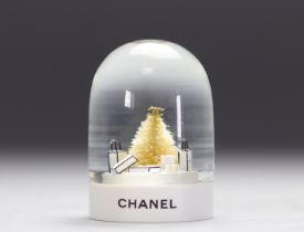 Chanel. Snow globe adorned with Chanel bags, fir tree and logo CC. Pvc base with inscription