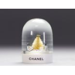 Chanel. Snow globe adorned with Chanel bags, fir tree and logo CC. Pvc base with inscription