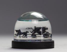Coach. Snow globe featuring a horse-drawn carriage with glitter. Imitation leather base