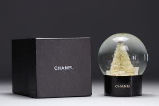 Chanel. Snow globe adorned with the No. 5 perfume bottle, bags, fir tree and topped with the CC log