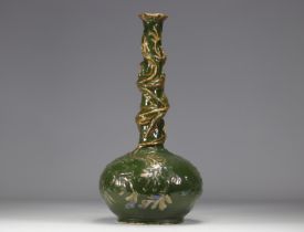 A gilded and iridescent earthenware vase on a green background decorated with chimeras from Austria