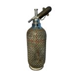 An early 20th century Sparklets Ltd of London glass soda siphon, with mesh design round glass, 35