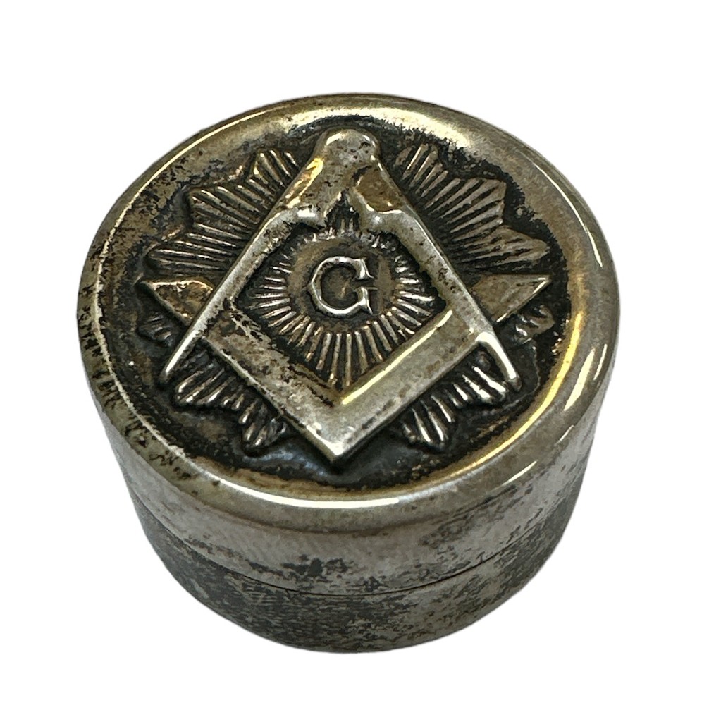 A small silver Masonic pill box with the Masonic emblem on the front. Marked 925 to base.