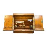 A two door hinged wooden writing slope with two inkwells and pen tray. Plus, two further ceramic ink