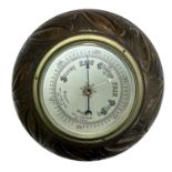 A 20th century wall barometer, round in carved wooden case. British Made. Diameter 23cm.