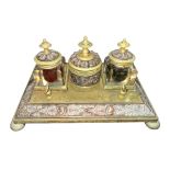 A brass decorative desk tidy with three inkwells, two glass (one damaged). With decorative dragonfly