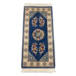A pair of blue and white (cream) rugs, oriental in style. Both approx. 150cm x 70cm.