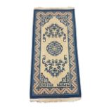 A Chinese ‘Peking’ blue and white rug. Approx 150cm x 70cm.
