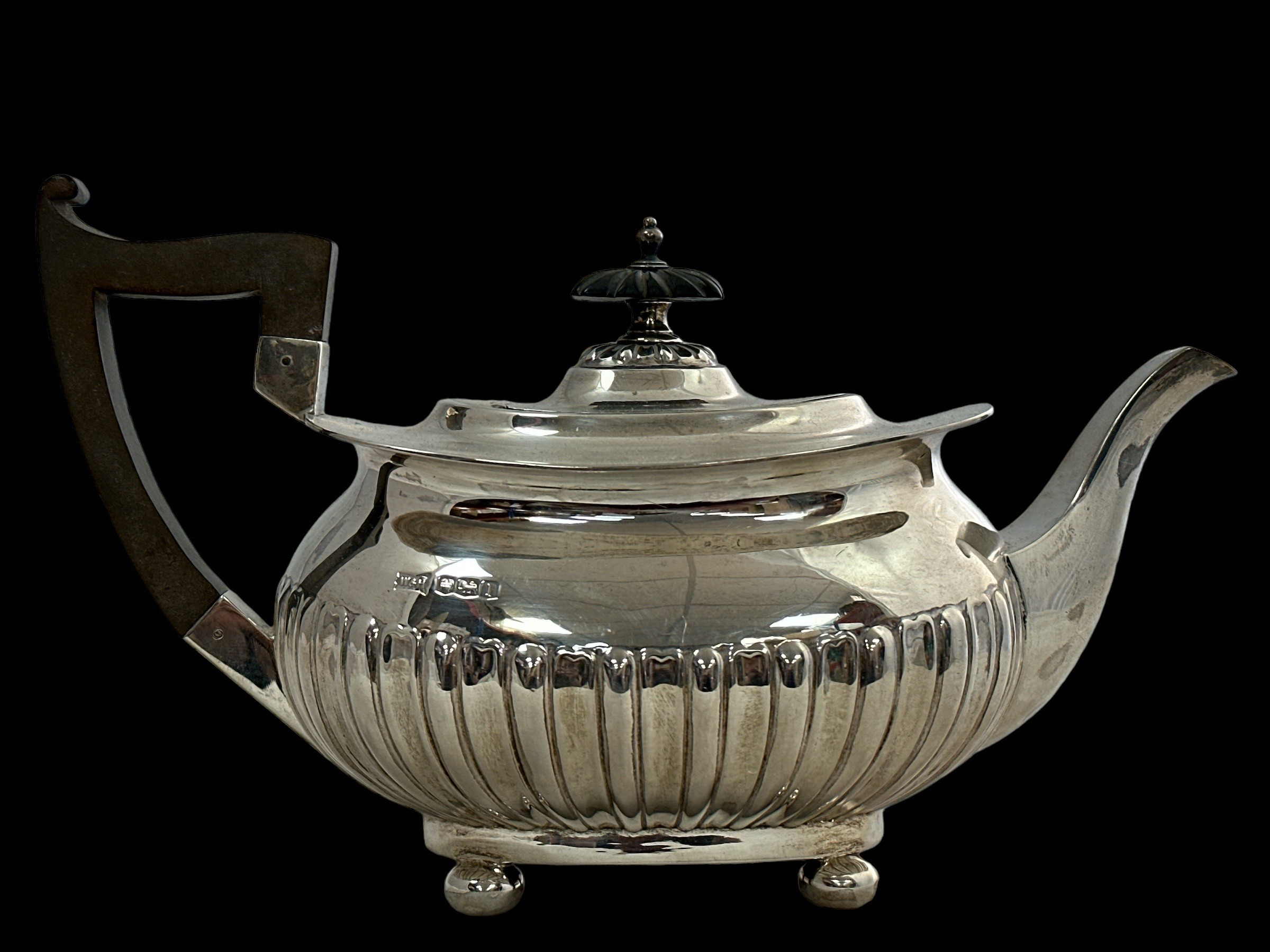 A silver teapot by Walker & Hall with a rectangular body with half fluted design, four ball feet,